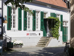 Außenansicht auf das Otto Modersohn Museum in Tecklenburg, Weißes Steinhaus Sprossenfenstern und grünen Fensterläden und grüner Eingangstür A